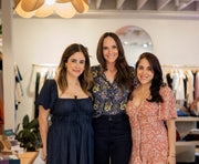 A group of women smiling indoors, possibly showcasing fashion or accessories related to WeNatal's prenatal supplements and lifestyle products.